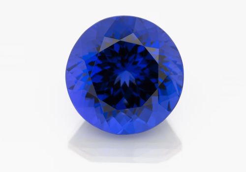 Vivid blue round tanzanite polished gemstone on white background