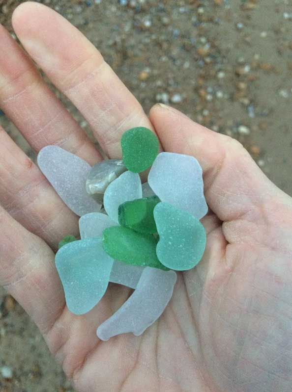 Images of beach glass pieces held in a hand at the beach