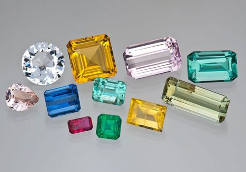 A group of beryl gemstones of various shapes, sizes, and colors
