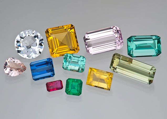 A group of beryl gemstones of various shapes, sizes, and colors