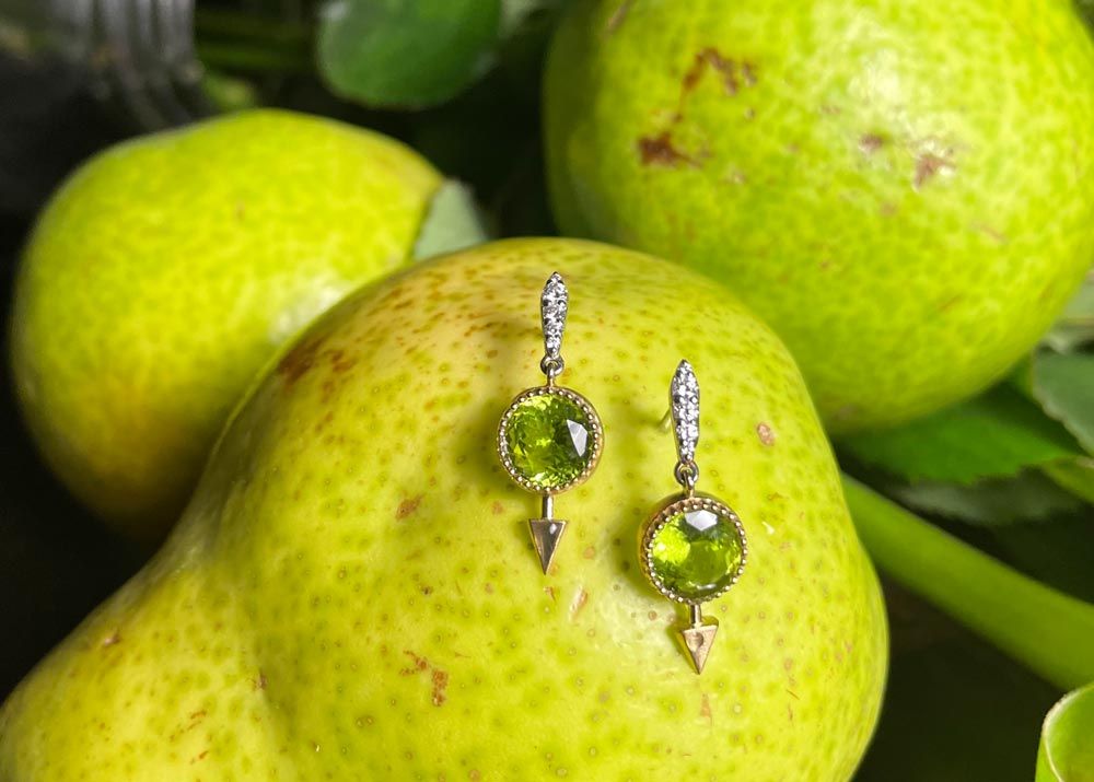 set of green peridot gemstone earrings resting on a pear