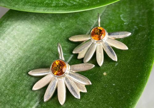 silver floral earrings with large vibrant orange citrine gemstones in the center
