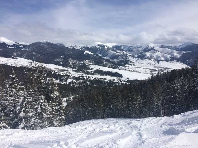 Photo of Montana wilderness in winter, with mountains in background and snow in foreground